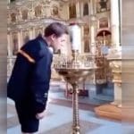 Accende una sigaretta sulle candele liturgiche della chiesa