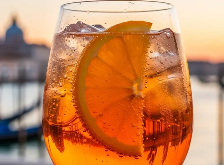 un calice da vino colmo di Spritz color arancio brillante