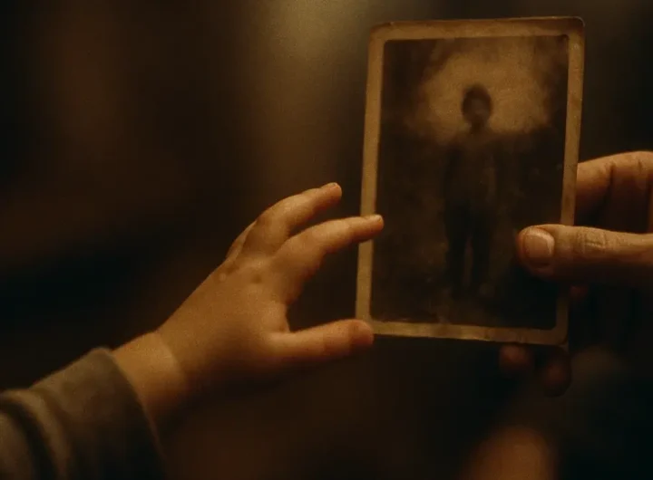 Bambino piccolo che guarda con curiosità una vecchia fotografia in bianco e nero