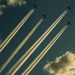 Scie lasciate da aerei nel cielo azzurro con nuvole sparse