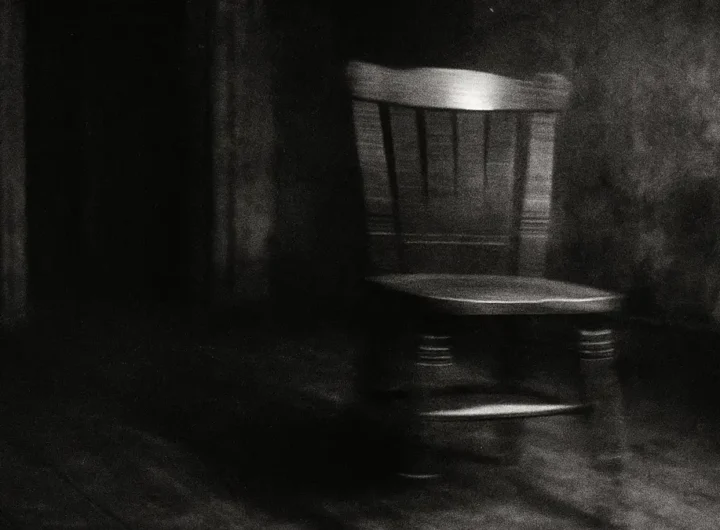 Fotografia sgranata di una sedia che si muove da sola in una stanza