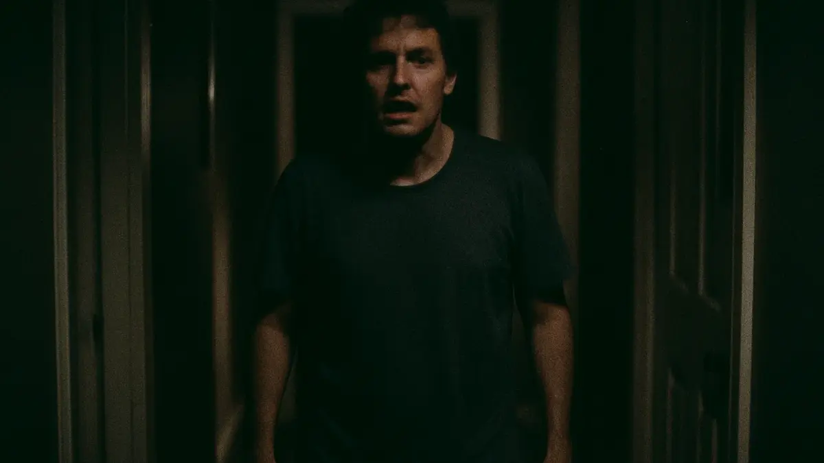 Primo piano di un adulto confuso e disorientato nel corridoio di casa