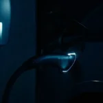 Uomo che ricarica un'auto Tesla di notte a casa con uno sfondo sfocato